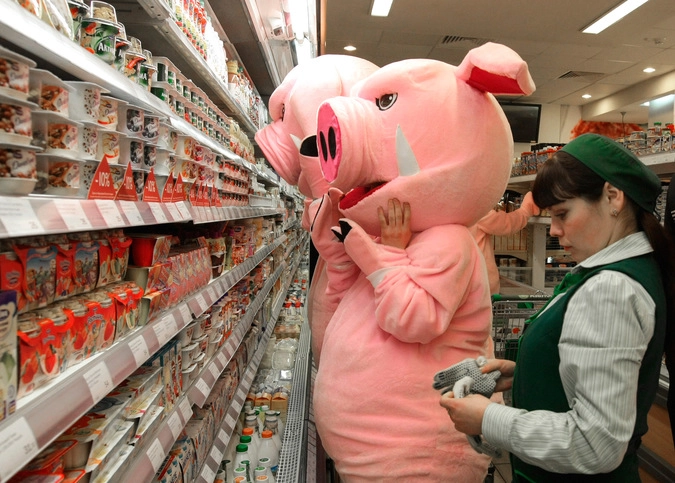 Переодетые в костюмы "хрюш" участники акции инспектируют выкладку одного из московских супермаркетов для выявления просроченных продуктов.
