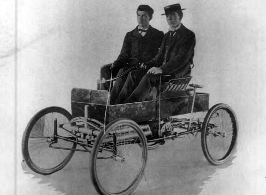 Гарри Нокс (на пассажирском месте) и четырёхколёсный Overman Victor, 1897 год. Как и на дальнейших конструкциях Нокса, мотор находился под кузовом в передней части шасси