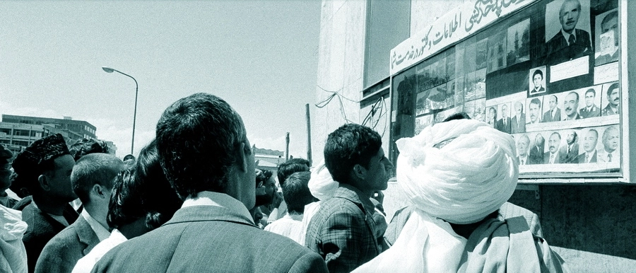 Афганцы у доски с фотографиями членов Революционного совета и нового правительства страны